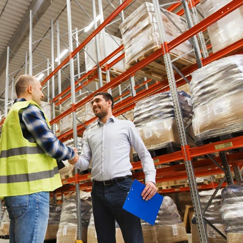 Worker and businessmen with clipboard at warehouse